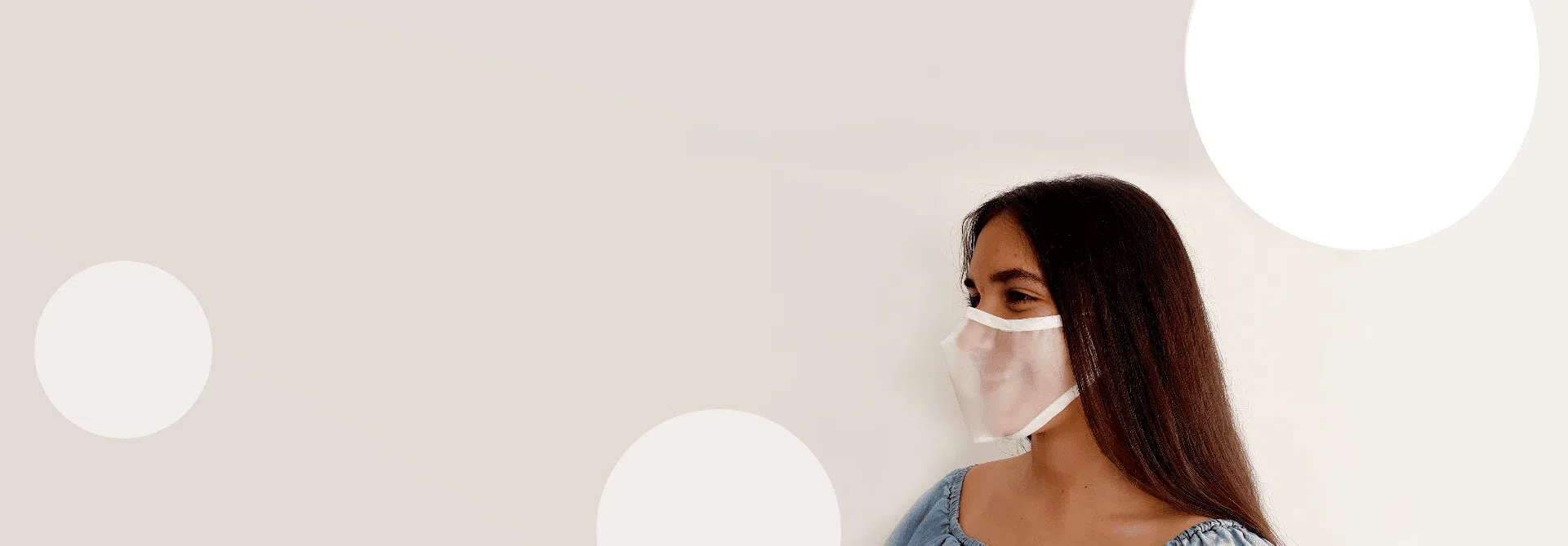 Niña con Mascarilla Transparente homologada sobre fondo de color topo de lunares